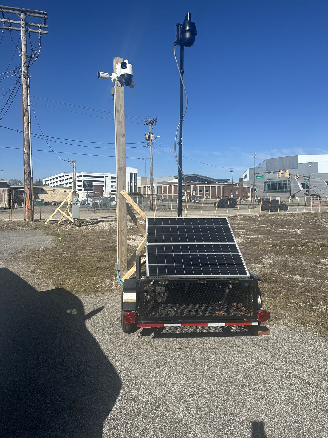 Mobile surveillance trailer with a mast-mounted PTZ camera and solar array deployed on site